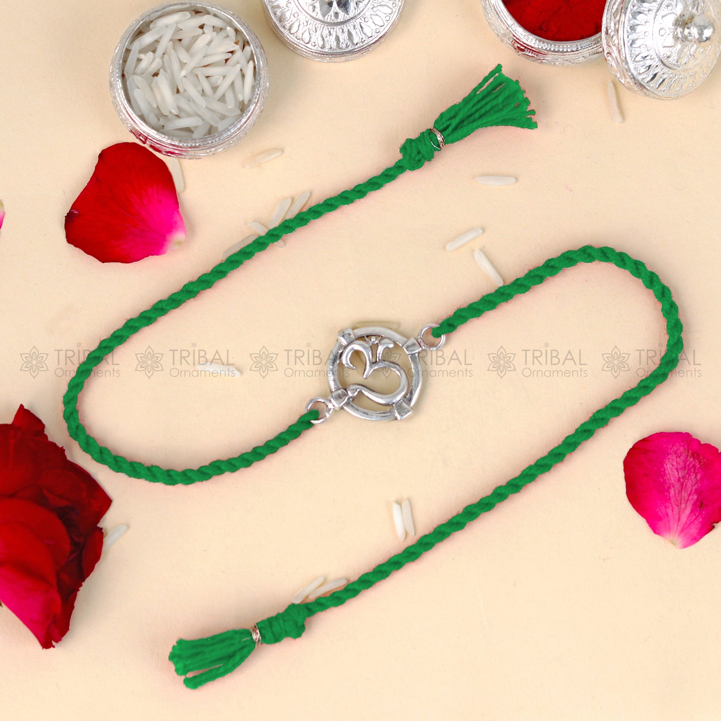 925 Sterling silver Om design thread rakhi bracelet with red thread from TRIBAL ORNAMENTS featuring a silver Om pendant.