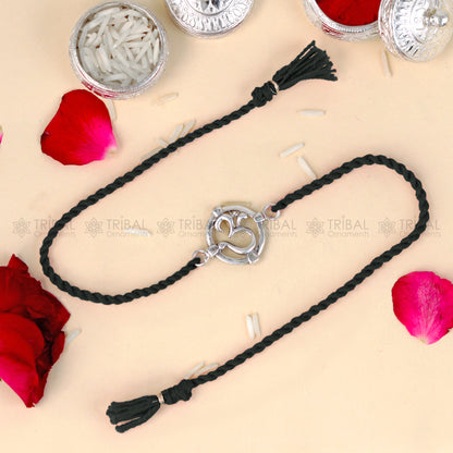 925 Sterling silver Om design thread bracelet with red thread from TRIBAL ORNAMENTS, featuring a pendant in a traditional style.