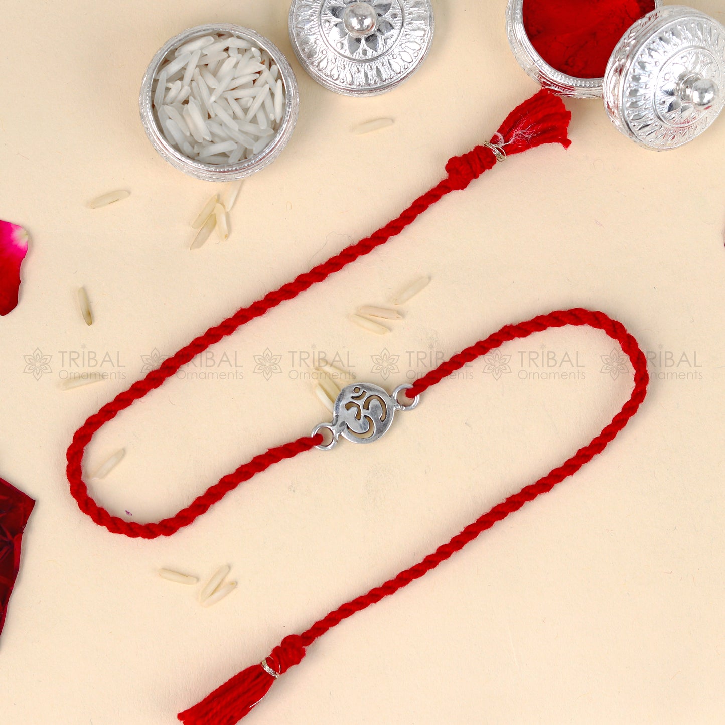 Sterling silver OM design thread rakhi bracelet with red thread and pendant, crafted by TRIBAL ORNAMENTS.