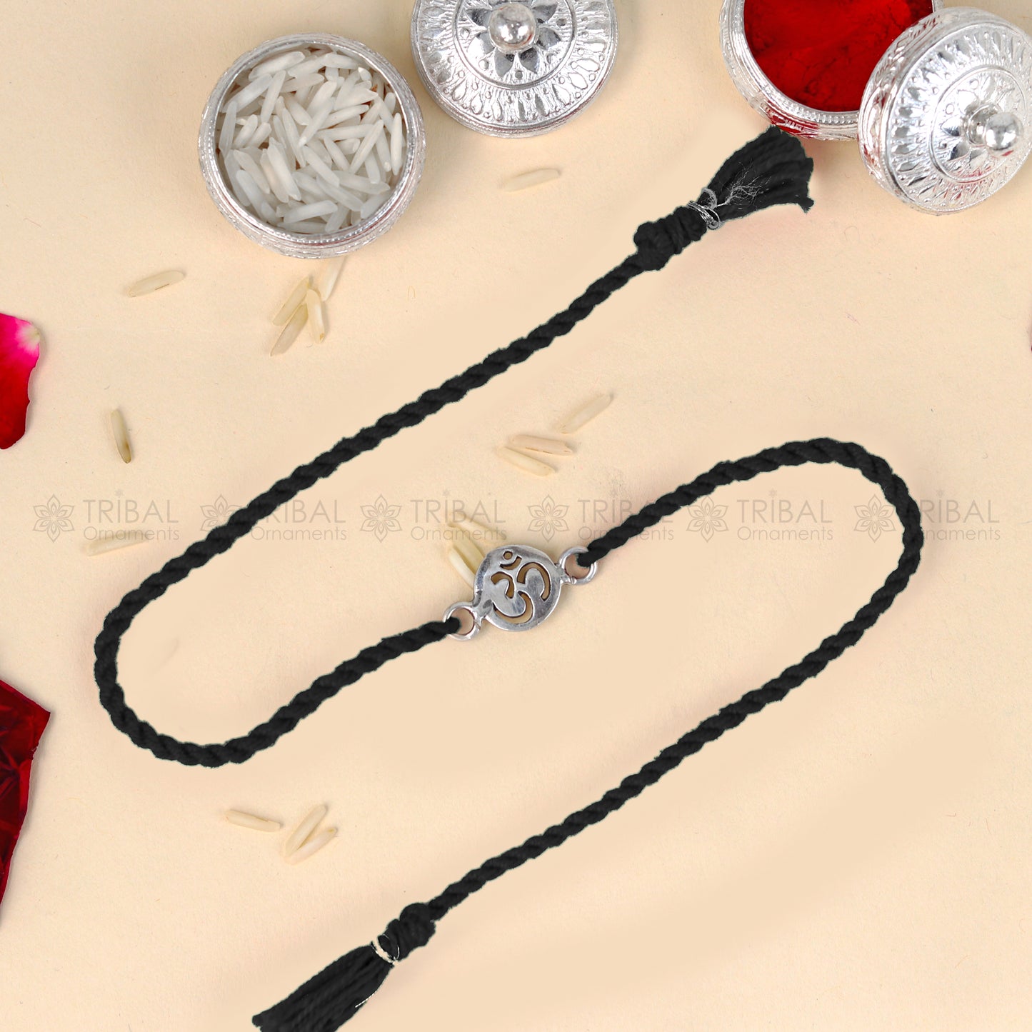 925 Sterling silver OM design thread rakhi bracelet with red thread from TRIBAL ORNAMENTS featuring a silver pendant.