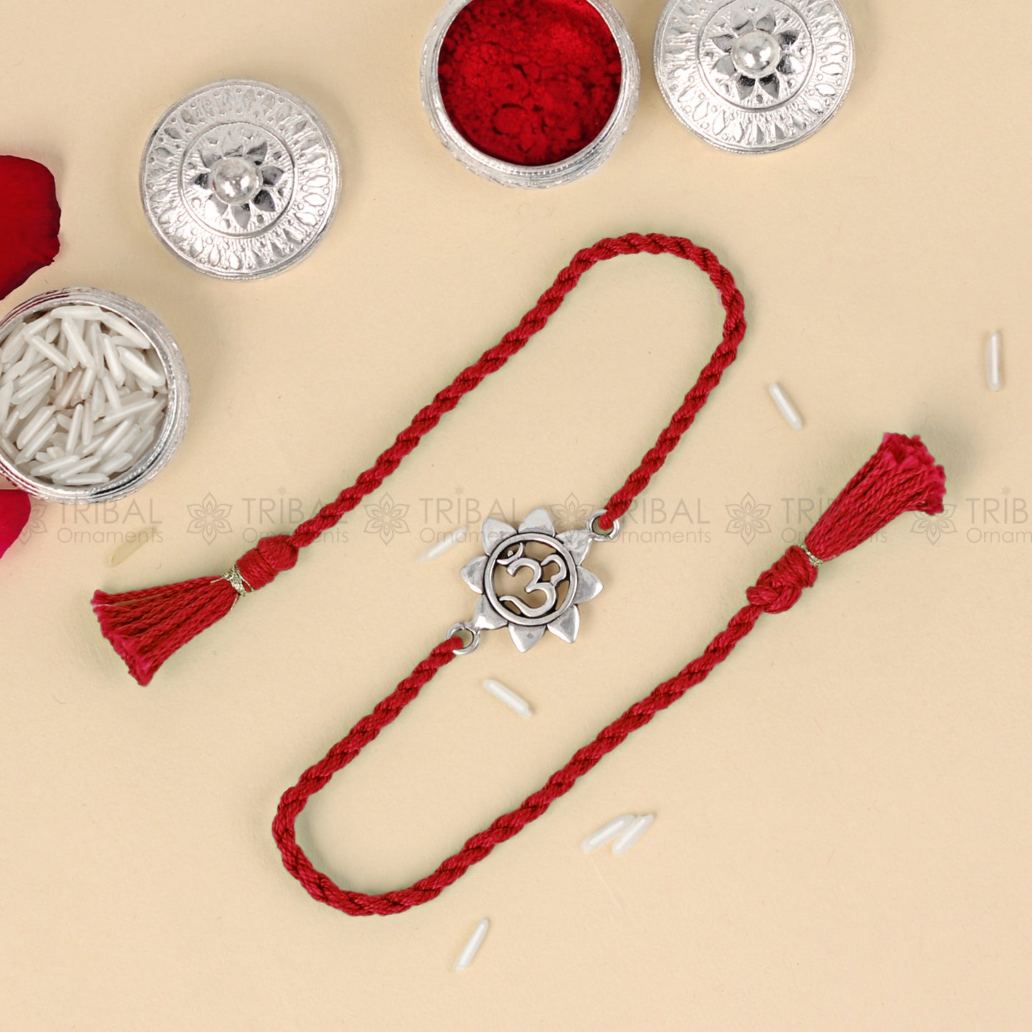 925 sterling silver Om design thread rakhi bracelet with red thread from TRIBAL ORNAMENTS, featuring a traditional Om pendant.