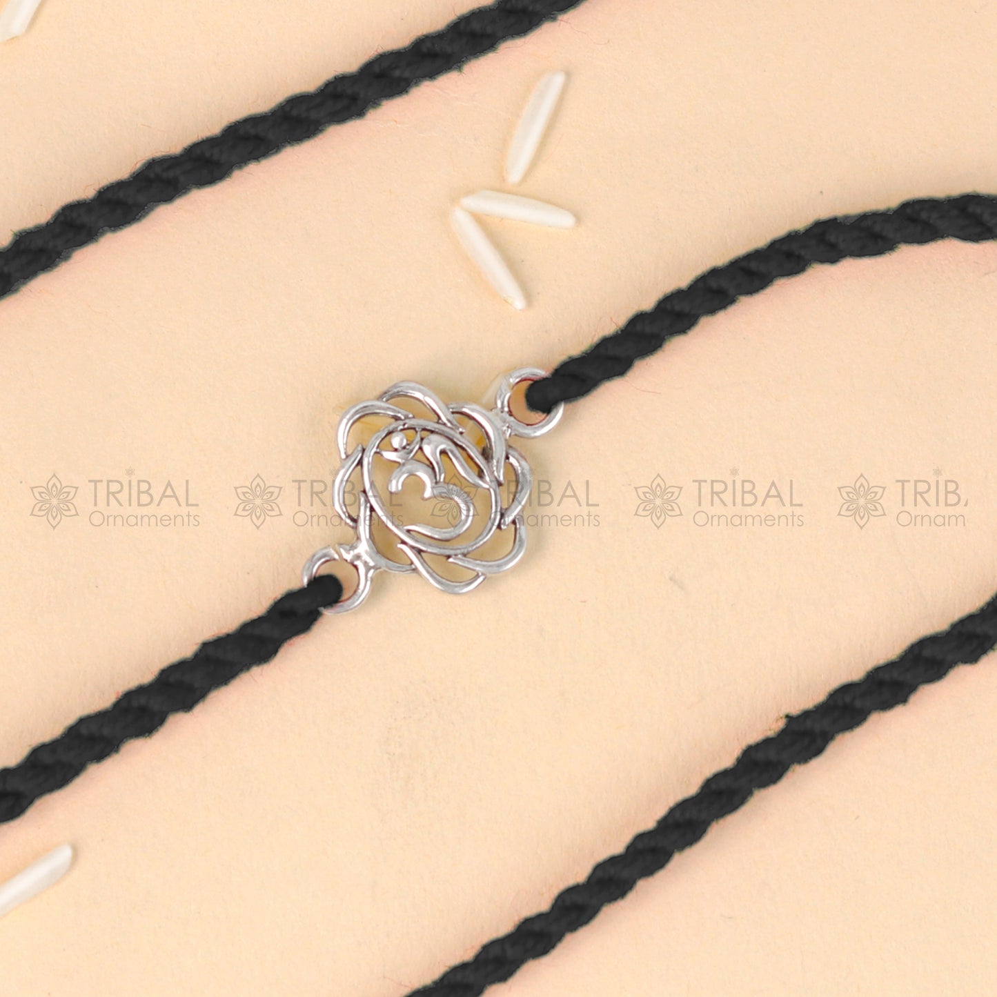 Sterling silver OM design thread rakhi bracelet by TRIBAL ORNAMENTS with red thread and silver pendant for Rakshabandhan festival