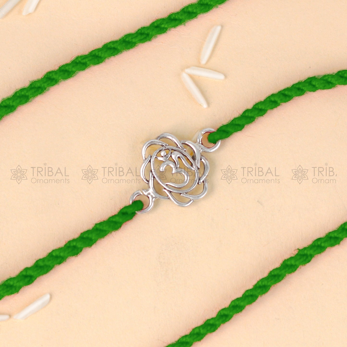 925 sterling silver OM design thread rakhi bracelet with red thread from Tribal Ornaments, featuring a pendant for Rakshabandhan celebration.