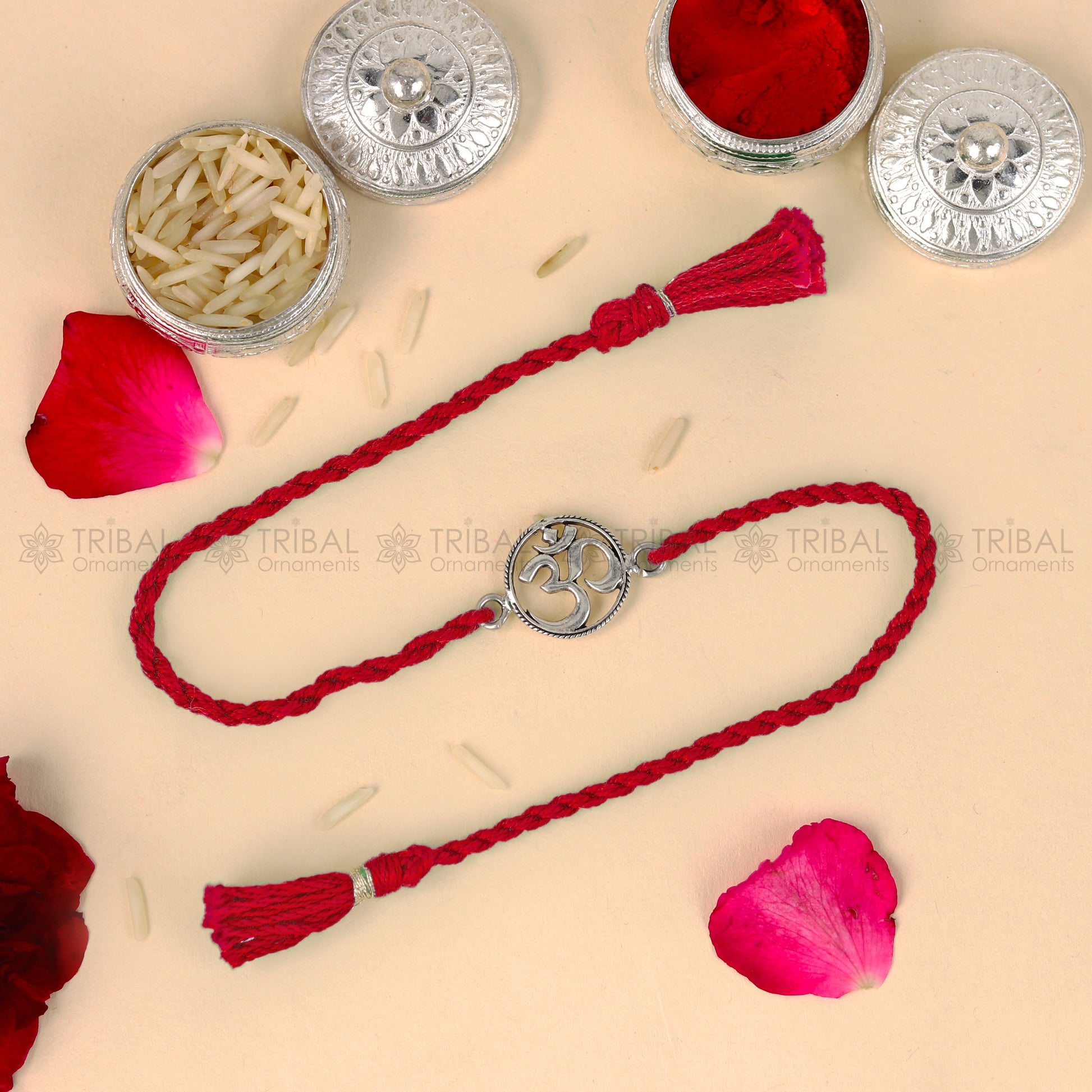 Sterling silver OM design thread rakhi bracelet with red thread from TRIBAL ORNAMENTS, perfect for Rakshabandhan festival.