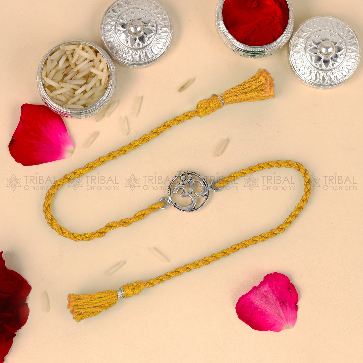 Sterling silver OM design thread rakhi bracelet with red thread from TRIBAL ORNAMENTS, perfect for Rakshabandhan festival.