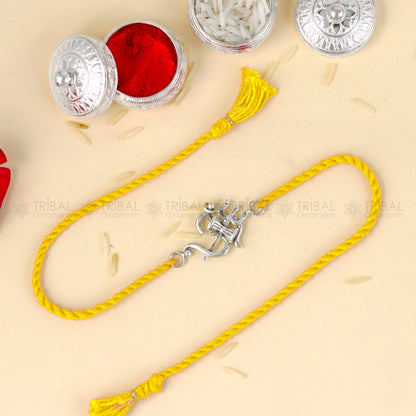 Sterling silver Om with trishul design thread bracelet by Tribal Ornaments on red thread, showcasing intricate silver pendant.