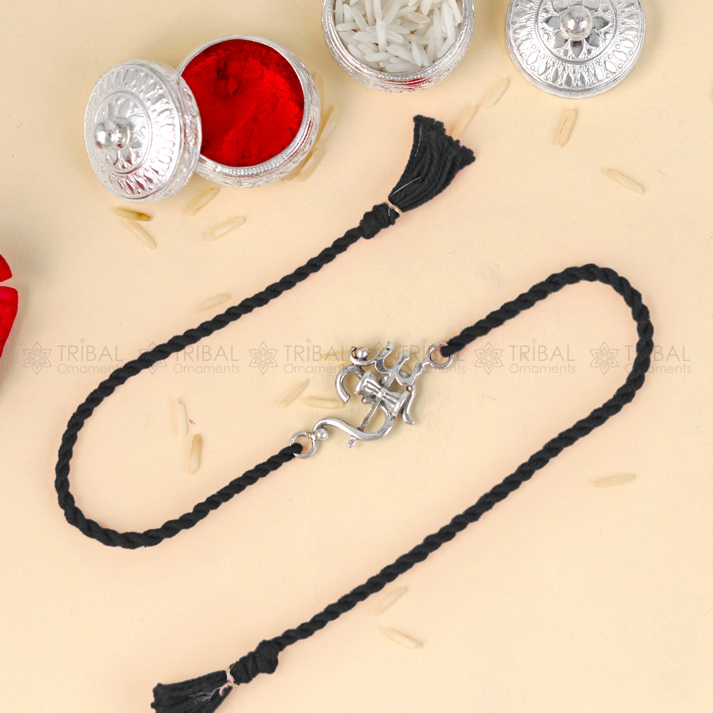 Sterling silver Om with trishul design thread rakhi bracelet by TRIBAL ORNAMENTS with red thread and intricate pendant detail