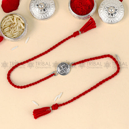 Sterling silver Swashtik design thread rakhi bracelet with red thread and pendant from TRIBAL ORNAMENTS.