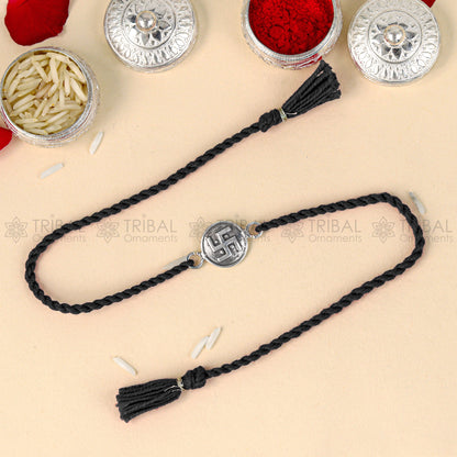 925 Sterling silver Swashtik design thread rakhi bracelet with red thread from TRIBAL ORNAMENTS, featuring a pendant charm.