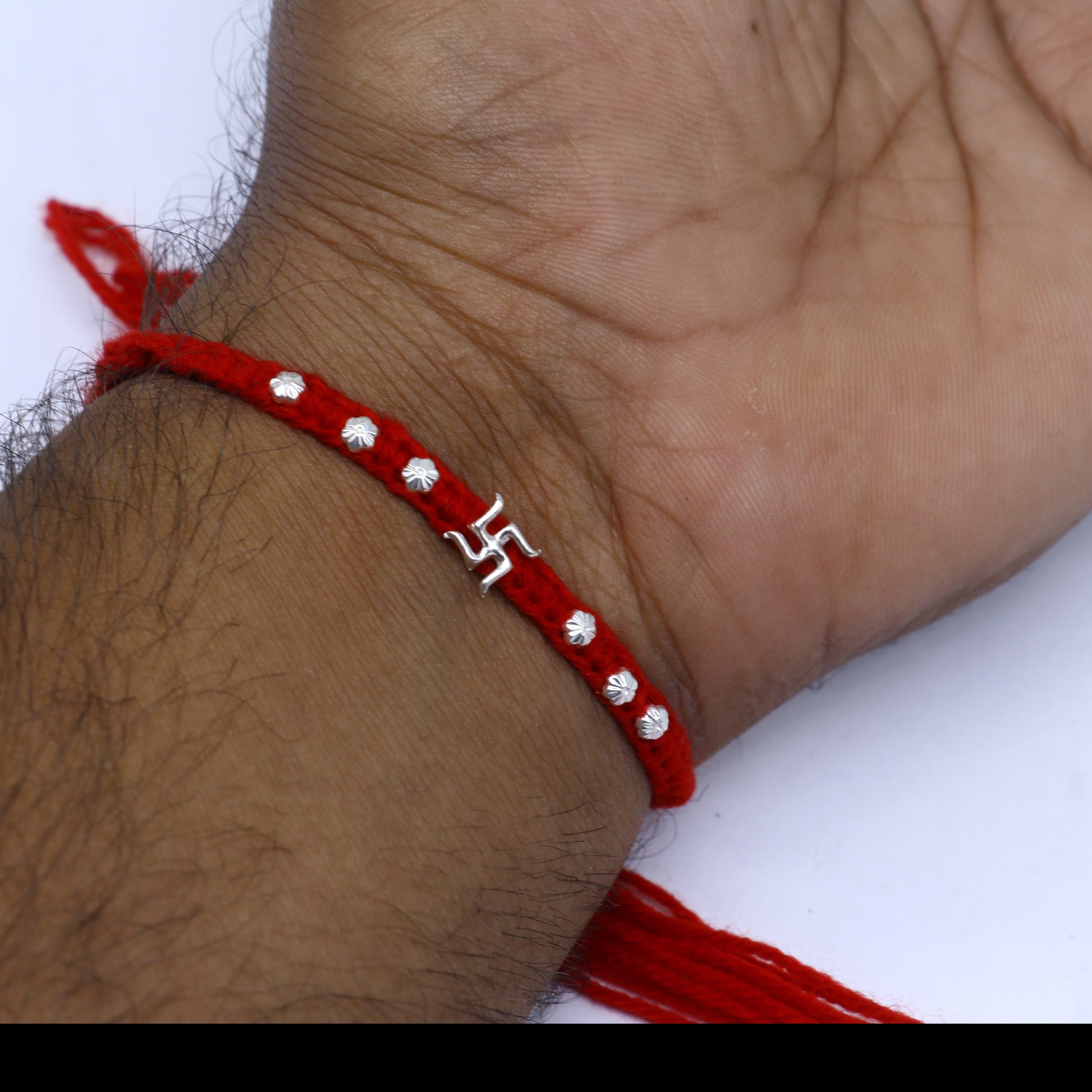 Sterling silver Swashtik design thread rakhi bracelet by TRIBAL ORNAMENTS with a pendant, perfect for Rakshabandhan celebrations.