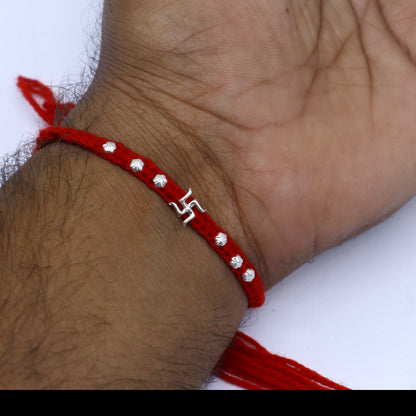 Sterling silver Swashtik design thread rakhi bracelet by TRIBAL ORNAMENTS with a pendant, perfect for Rakshabandhan celebrations.