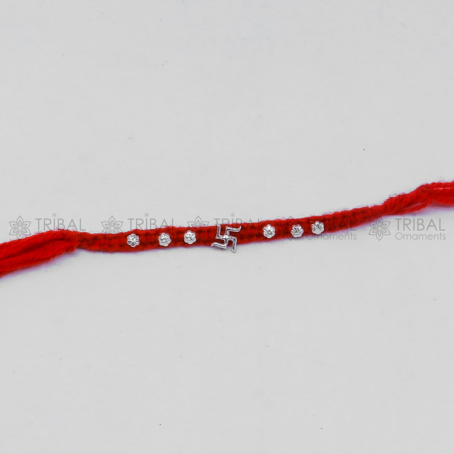 Sterling silver Swashtik design thread rakhi bracelet by TRIBAL ORNAMENTS with intricate pendant for Rakshabandhan festival.