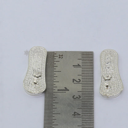 Handmade sterling silver Charan paduka slippers for Krishna idols, featuring intricate traditional design by TRIBAL ORNAMENTS.