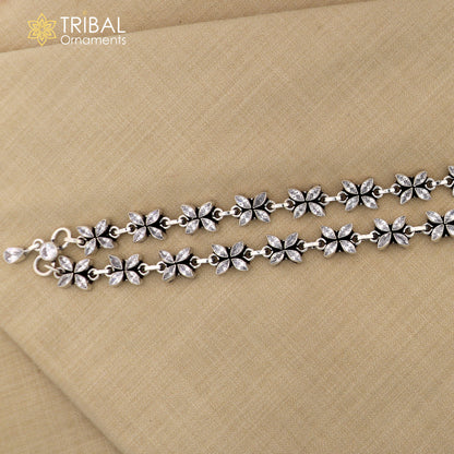 Sterling silver 10-inch flower design anklet with white stones from TRIBAL ORNAMENTS, featuring intricate floral details.