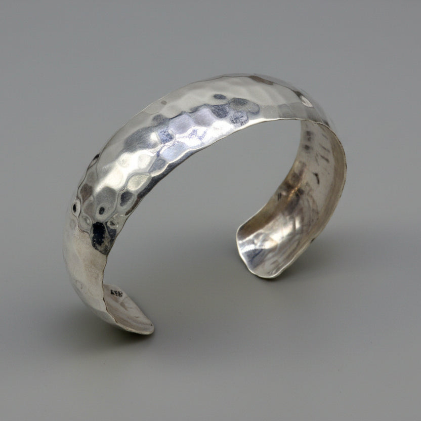 Sterling silver adjustable bangle bracelet with shiny spotted design, by TRIBAL ORNAMENTS, showcasing a sleek, unique cuff style.