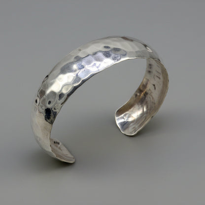 Sterling silver adjustable bangle bracelet with shiny spotted design, by TRIBAL ORNAMENTS, showcasing a sleek, unique cuff style.