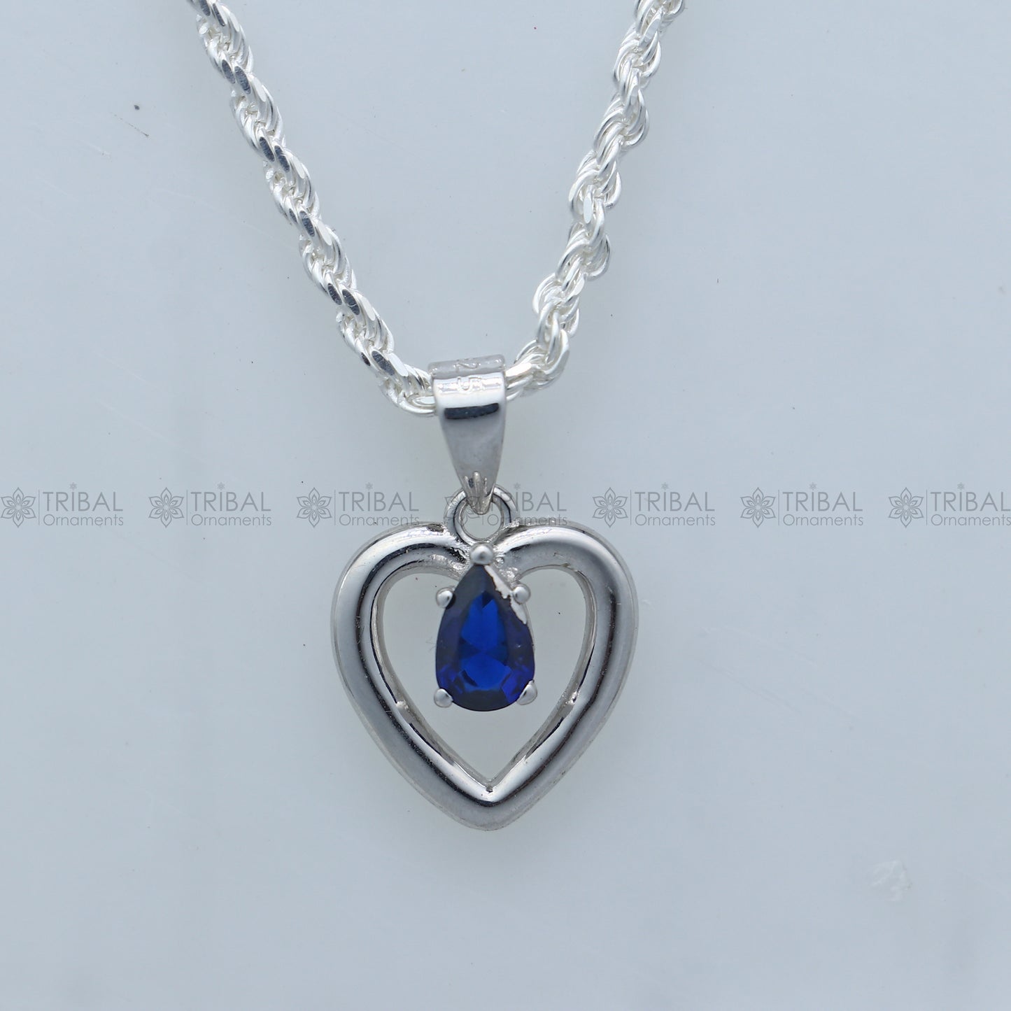 925 Sterling silver pendant set with blue sapphire heart-shaped gemstone, featuring a matching necklace and earring design.