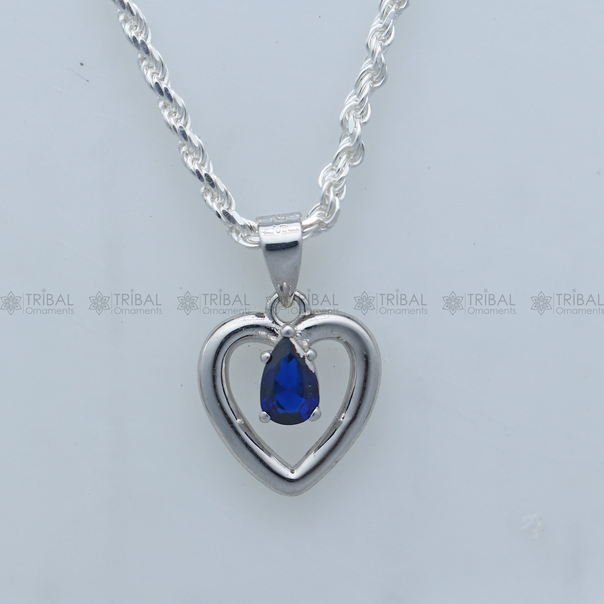 925 Sterling silver pendant set with blue sapphire heart-shaped gemstone, featuring a matching necklace and earring design.