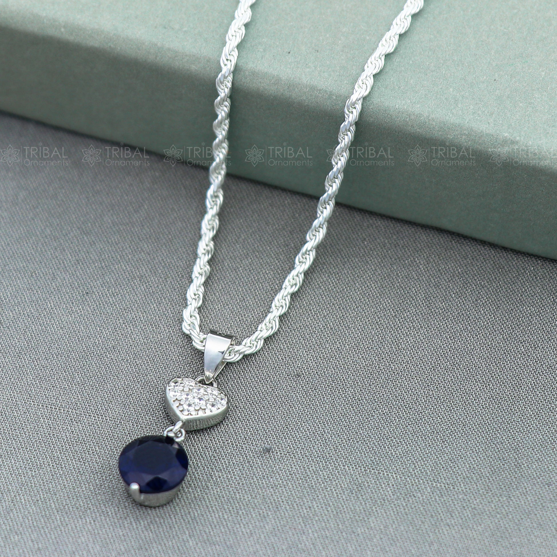 925 Sterling silver pendant set with round blue sapphire diamond, featuring a polished, elegant design by Tribal Ornaments.