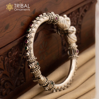 Sterling silver customized peacock bangle from TRIBAL ORNAMENTS, featuring tribal design and intricate peacock motif.