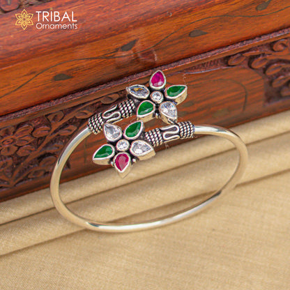 Sterling silver cuff bangle bracelet with red and green cut stones, tribal ornament design, stylish kada bracelet.