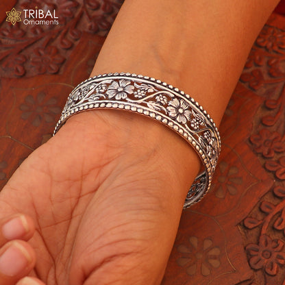 Sterling silver floral design customized bangle kada jewelry by TRIBAL ORNAMENTS, showcasing intricate floral patterns on a silver bracelet.