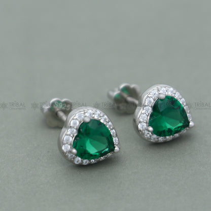 Sterling silver heart-shaped pendant set with green emerald diamond from TRIBAL ORNAMENTS, showcasing a detailed jewelry design.