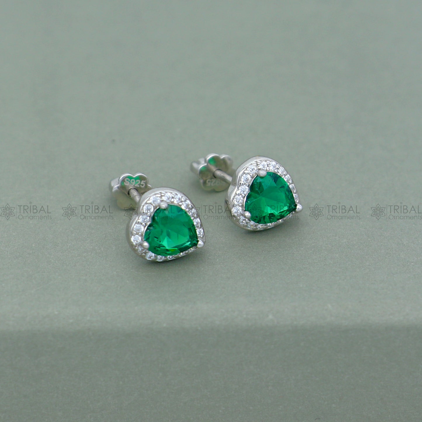 Sterling silver heart-shaped pendant set with green emerald diamonds, crafted by Tribal Ornaments.