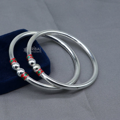 Sterling silver bangle bracelet with smooth, shiny ball design by TRIBAL ORNAMENTS, showcasing handcrafted jewelry style.