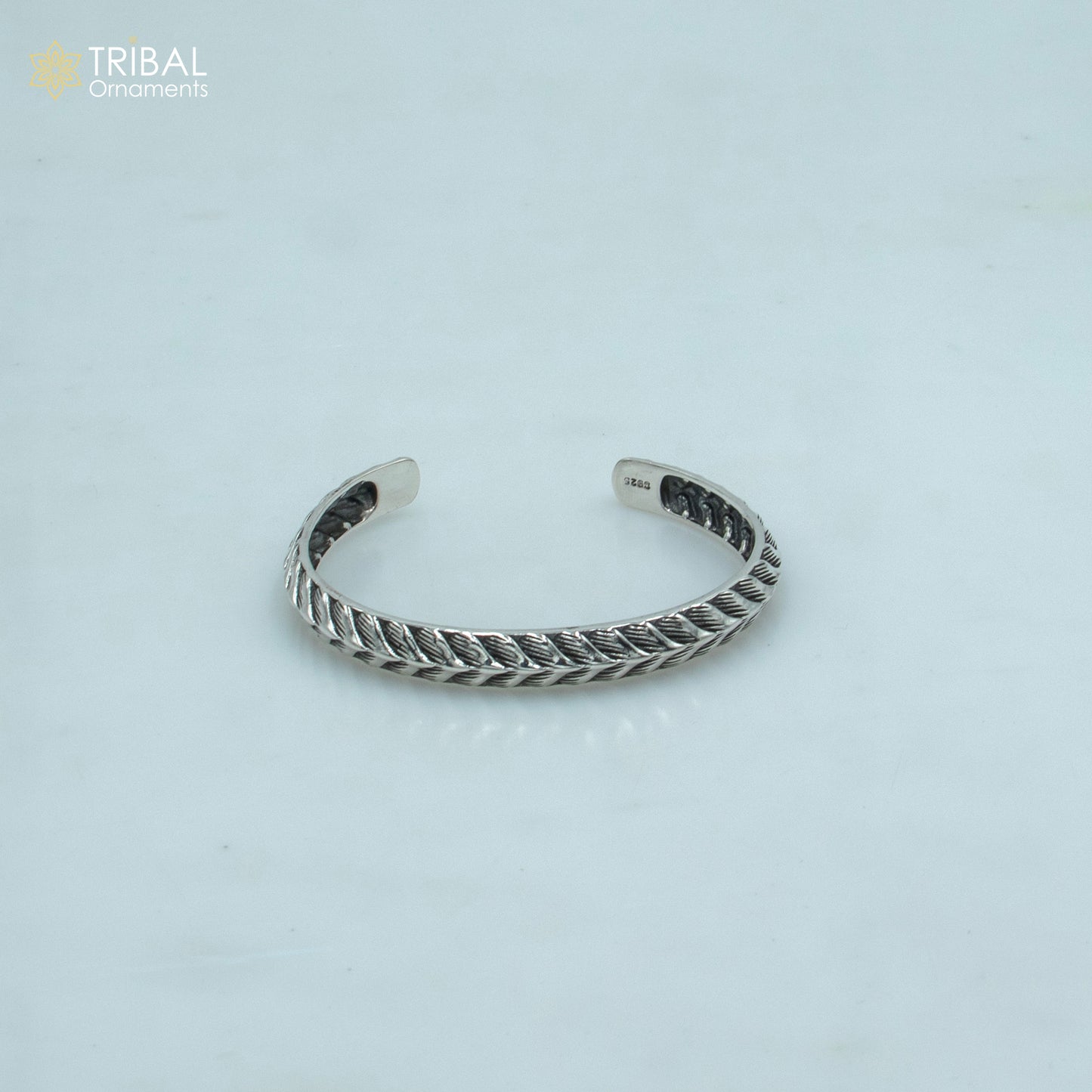 Sterling silver handmade adjustable bangle bracelet by Tribal Ornaments, unisex stylish cuff jewelry with intricate design.