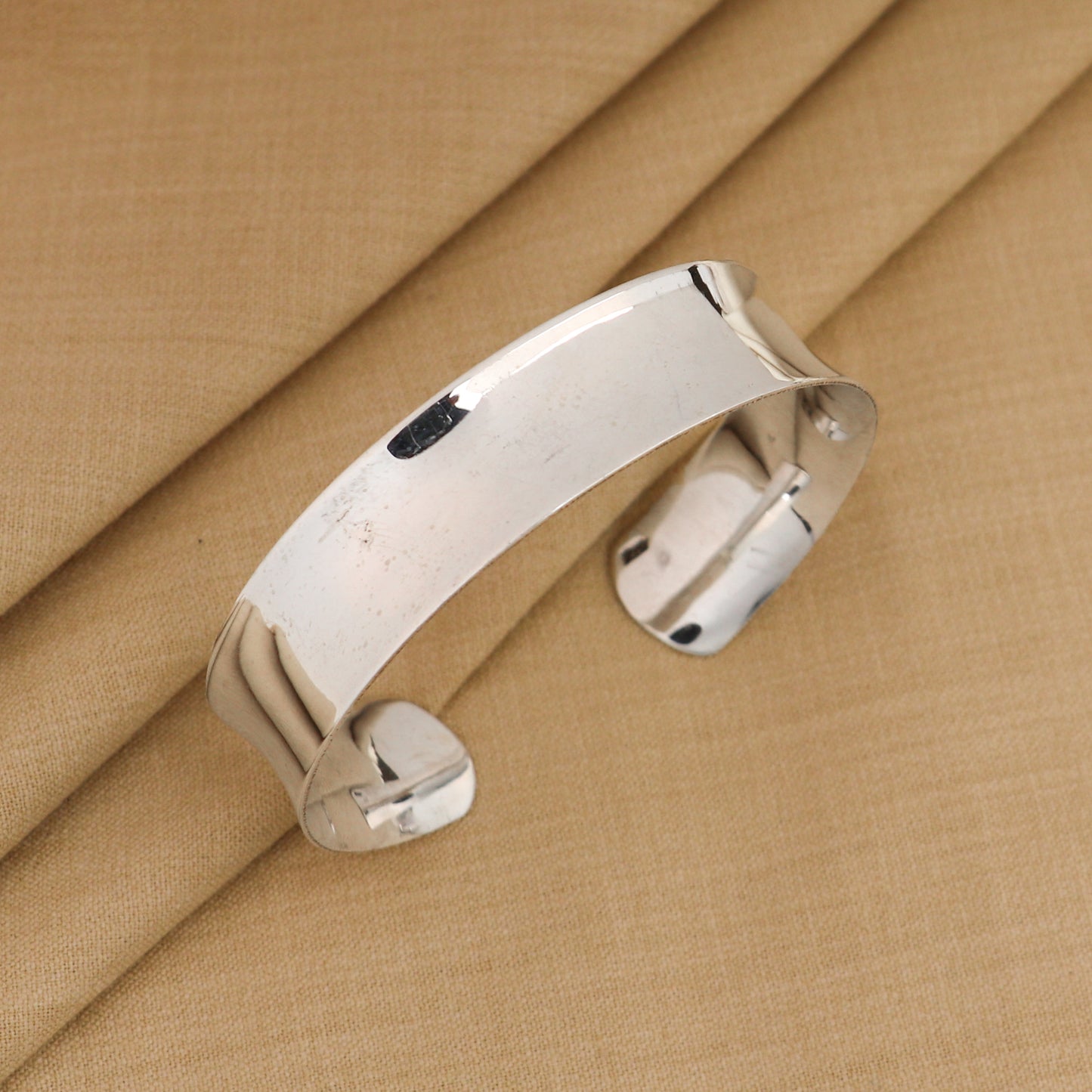 Sterling silver bangle bracelet with a shiny, plain design from TRIBAL ORNAMENTS, stylish cuff jewelry for gifting or everyday wear.