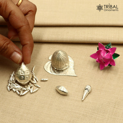 925 sterling silver pooja accessories with supari, paan leaves, rice, cloves, coconut, cardamom, and flowers for worship.