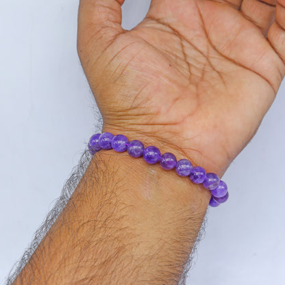 Amethyst bracelet by TRIBAL ORNAMENTS featuring polished purple stones on an elastic band, designed for calm and clarity.