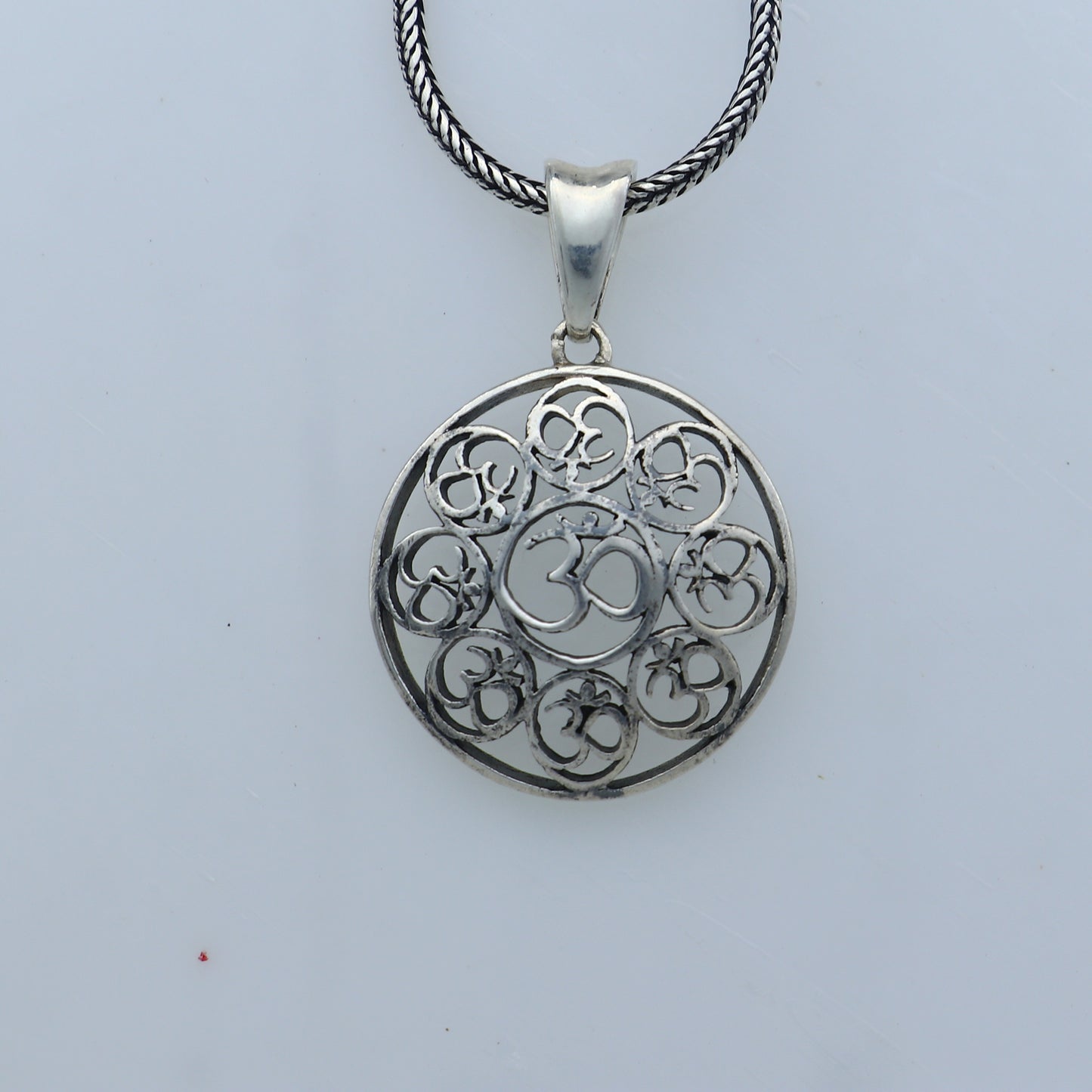 925 Sterling silver Om pendant featuring Om mantra design from Tribal Ornaments, showcasing intricate craftsmanship and religious symbolism.