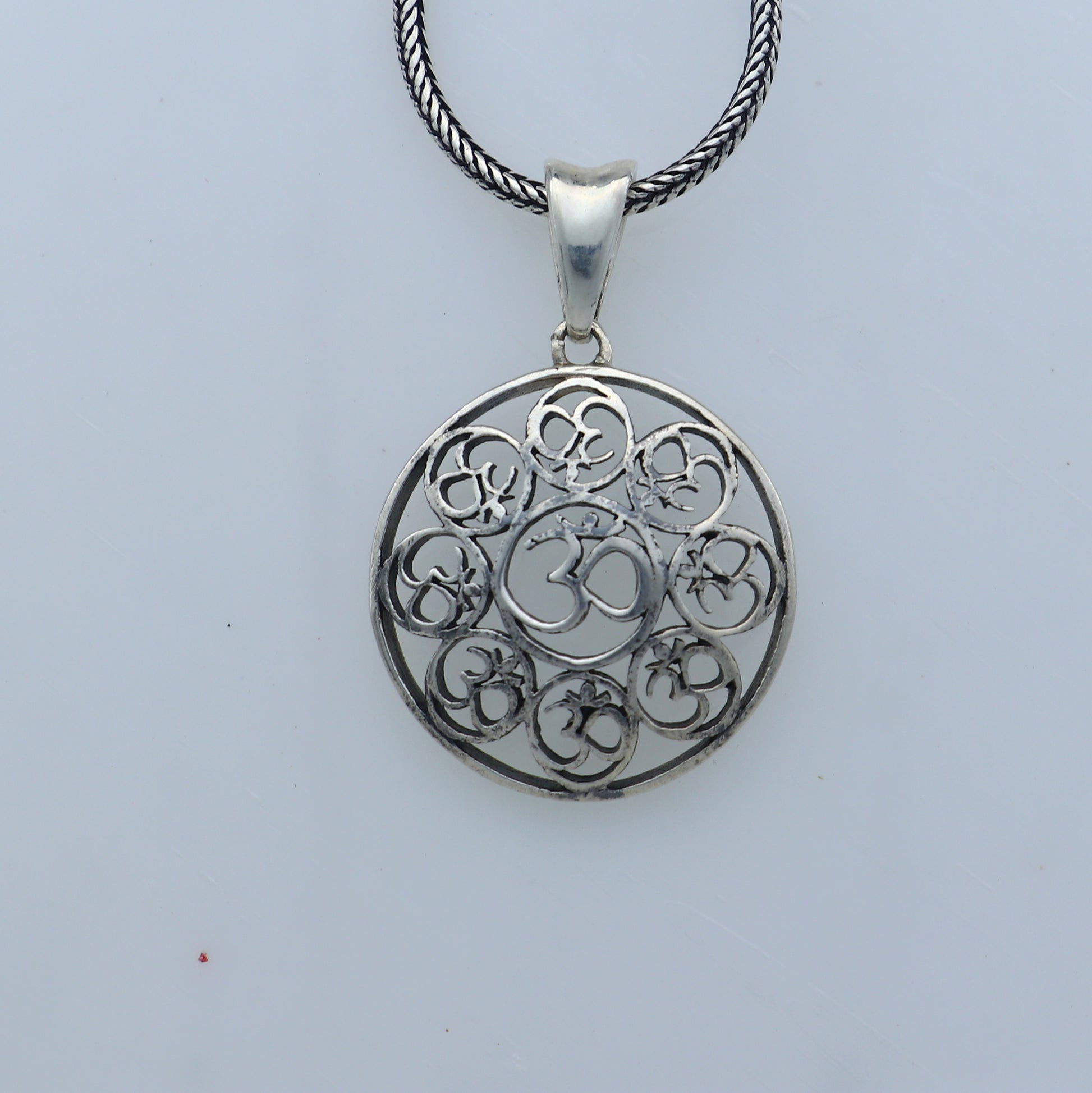 925 Sterling silver Om pendant featuring Om mantra design from Tribal Ornaments, showcasing intricate craftsmanship and religious symbolism.