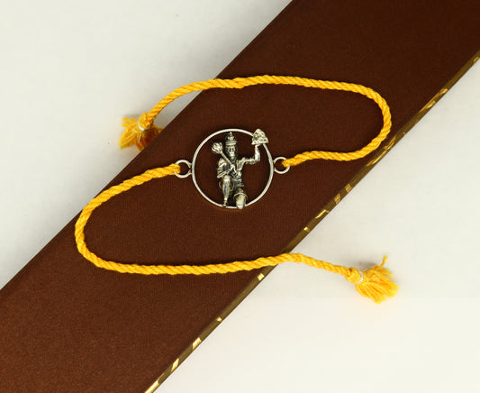 Sterling silver Hanuman idol bracelet with red thread rakhi, featuring intricate tribal design and craftsmanship from Tribal Ornaments.