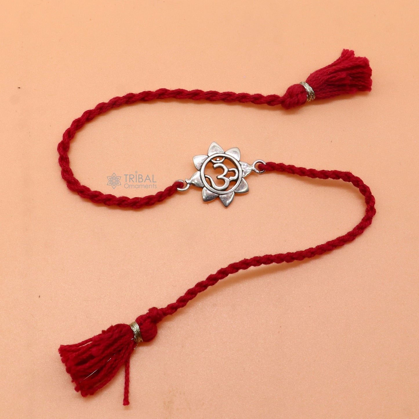 Sterling silver "AUM or OM" mantra thread rakhi bracelet with red thread from TRIBAL ORNAMENTS, traditional spiritual jewelry.