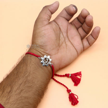 925 Sterling silver AUM OM mantra thread rakhi bracelet with red thread from TRIBAL ORNAMENTS, featuring intricate silver detailing.
