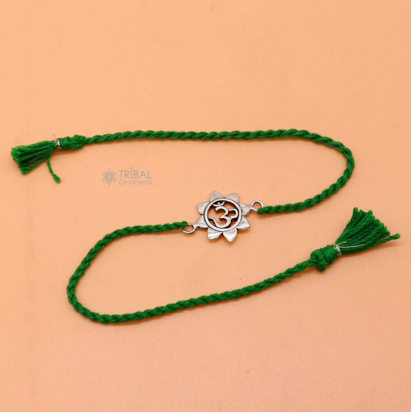 Sterling silver "AUM OM" mantra thread rakhi bracelet with red thread and tribal ornaments, designed by Tribal Ornaments.