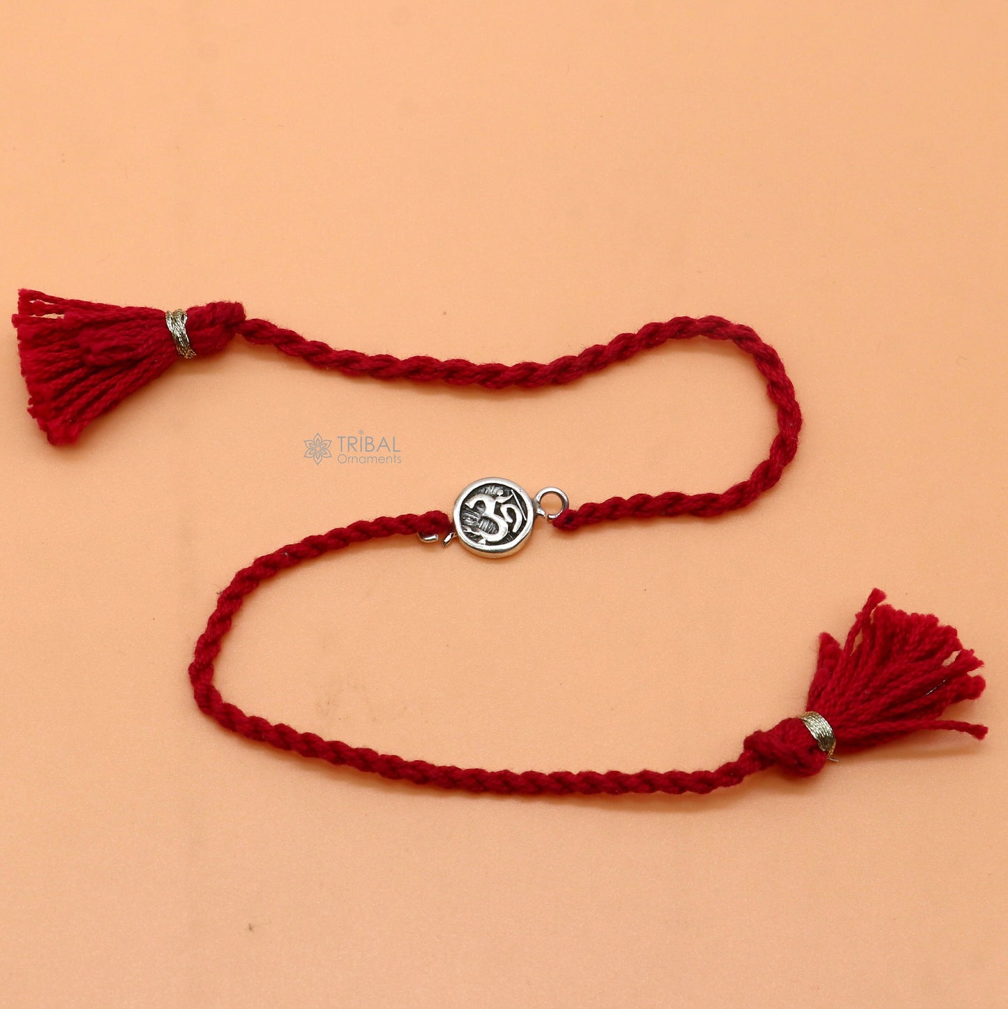 925 Sterling silver Hindu mantra "Aum" OM design thread rakhi bracelet with red thread and pendant by TRIBAL ORNAMENTS.