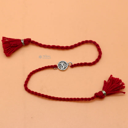 925 Sterling silver Hindu mantra "Aum" OM design thread rakhi bracelet with red thread and pendant by TRIBAL ORNAMENTS.