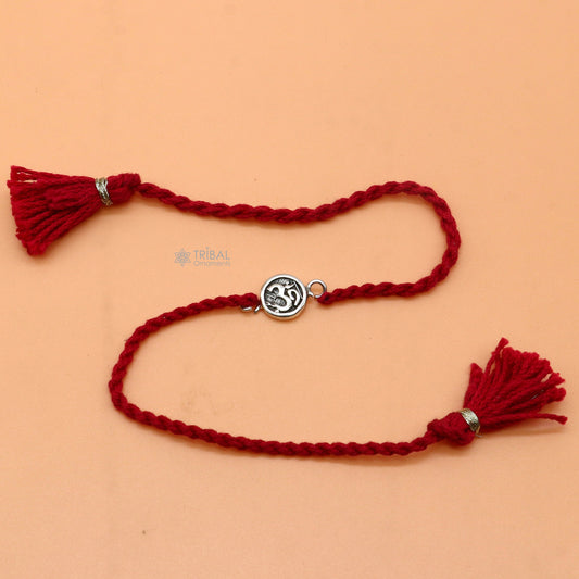 925 Sterling silver Hindu mantra "Aum" OM design thread rakhi bracelet with red thread and pendant by TRIBAL ORNAMENTS.