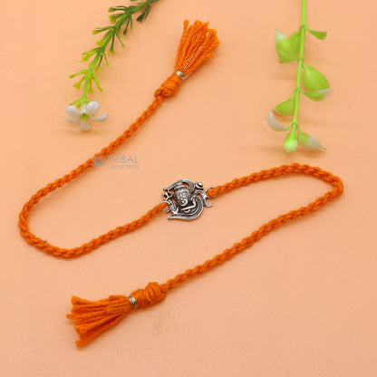 Sterling silver Lord Shiva with Aum design thread rakhi bracelet featuring red thread from TRIBAL ORNAMENTS.