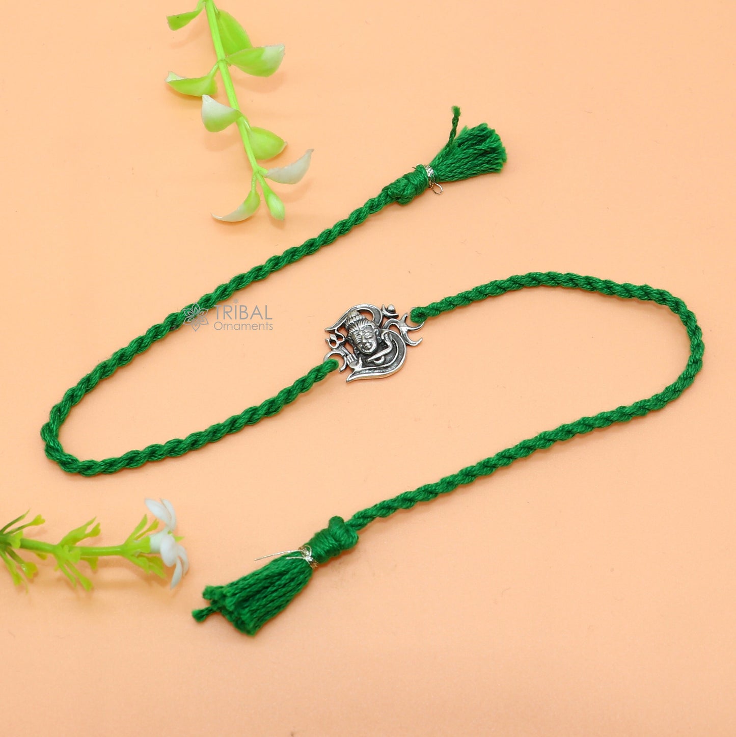 Sterling silver Lord Shiva with Aum design thread rakhi bracelet by TRIBAL ORNAMENTS featuring red thread and intricate silver pendant.