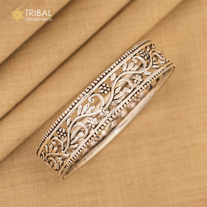 Sterling silver wide floral design bangle bracelet by TRIBAL ORNAMENTS, showcasing intricate ethnic style and customizable jewelry features.