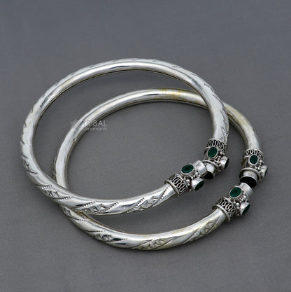 Sterling silver ankle kada bracelet with a stylish design and a vibrant green stone, featuring a tribal ornament brand.