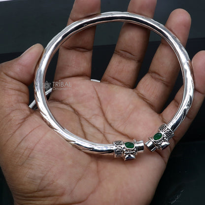 Sterling silver ankle kada bracelet with a stylish design and a vibrant green stone, featuring a trendy tribal ornament style.