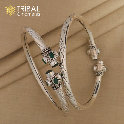 Sterling silver ankle kada bracelet with stylish design and a vibrant green stone, featuring a trendy tribal ornament style.