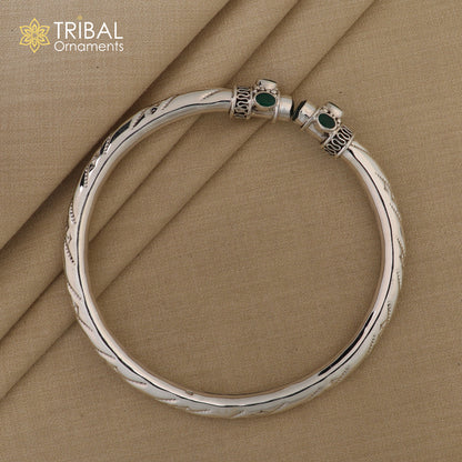 Sterling silver ankle kada bracelet with a stylish design and a green stone, featuring intricate craftsmanship and an elegant appearance.
