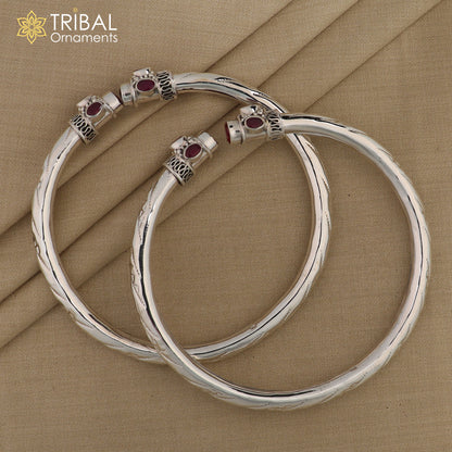 Sterling silver ankle kada bracelet with stylish design and red stone accent, featuring a foot-shaped ornament.